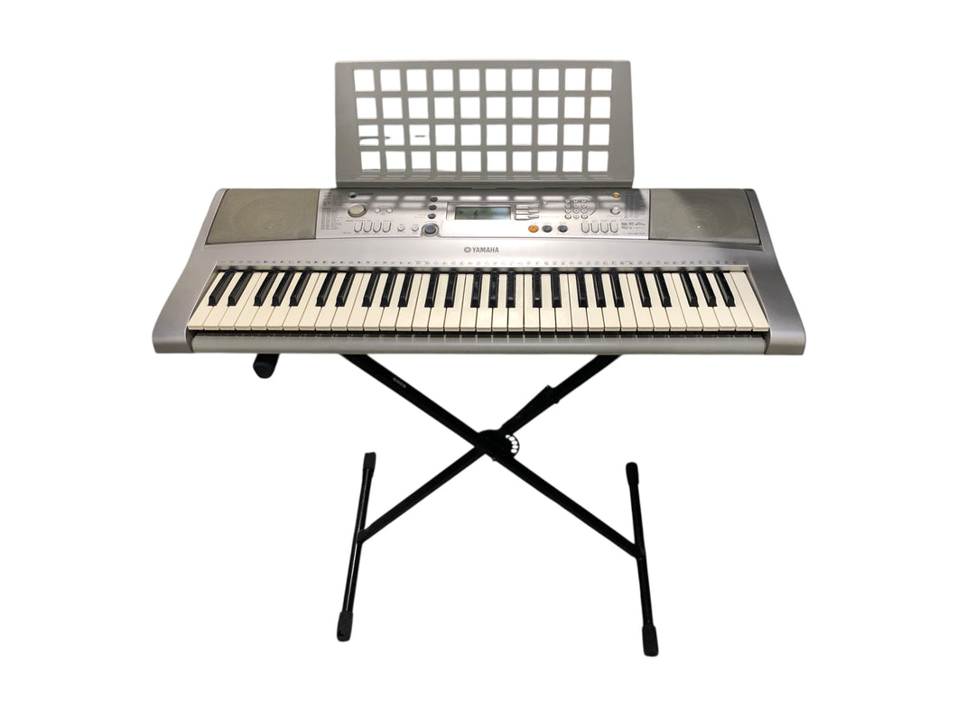 Teclado Portátil marca Yamaha en color Gris. Modelo (PSR-E303), incluye soporte y porta notas. Artículo de doble uso.